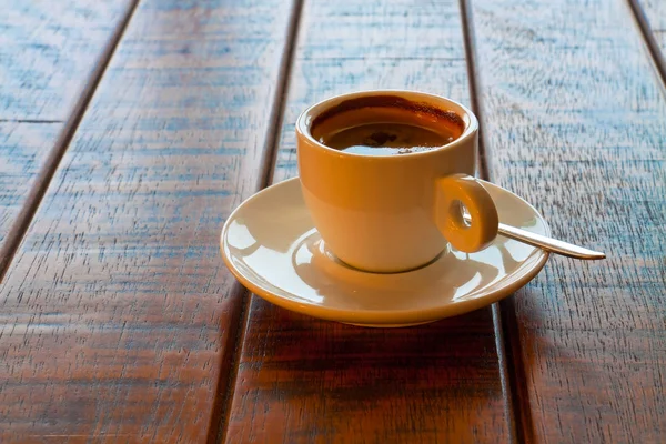 Cup of coffee on wooden table — Stock Photo, Image