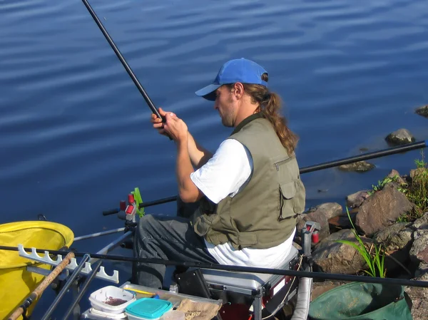 坐着钓鱼离海岸线的男子 — 图库照片