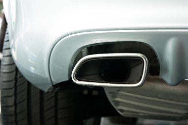 Stainless steel exhaust pipes on a silver car clipart