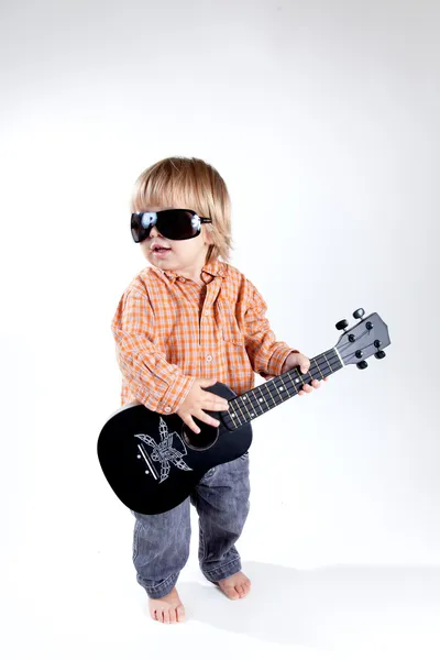 Αστείο μικρό αγόρι με το γιουκαλίλι κιθάρα — Φωτογραφία Αρχείου
