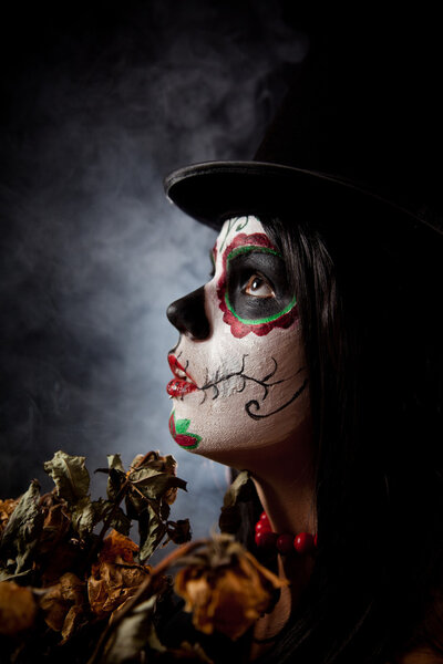 Sugar skull woman in tophat, holding dead roses