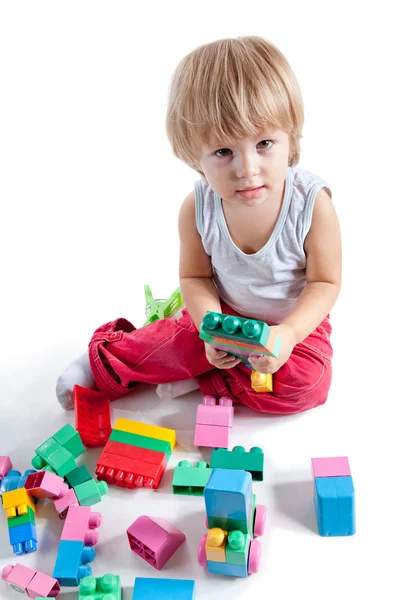 Lindo niño jugando con bloques de colores — Stok fotoğraf