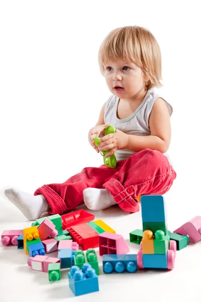 Bonito menino brincando com blocos coloridos — Fotografia de Stock