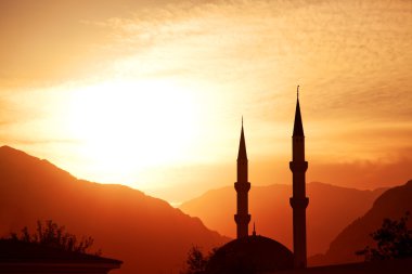Mosque silhouette at sunset, with mountains on background, Turkey, Kemer clipart