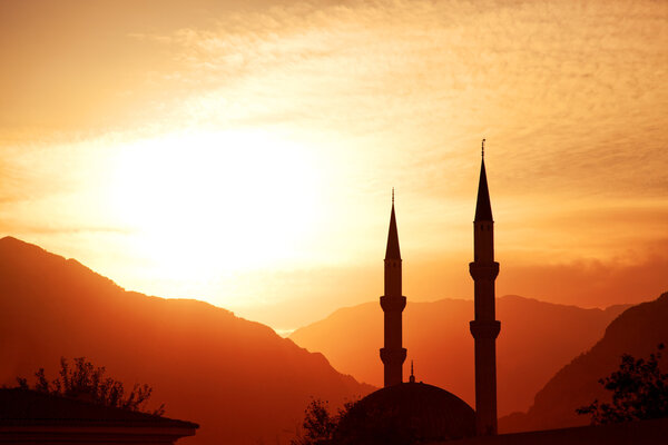 Mosque silhouette at sunset, with mountains on background, Turkey, Kemer