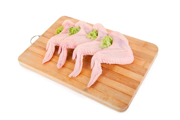 Asas de frango cru com salada verde na tábua de madeira — Fotografia de Stock