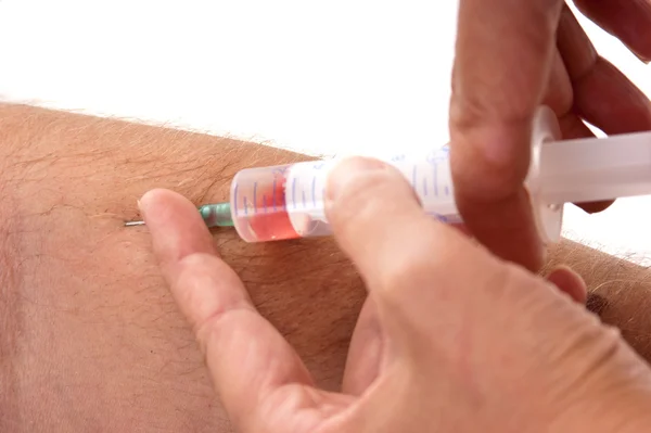 Doc makes the patient an injection into a vein