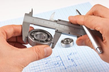 Technical drawing and callipers with bearing in hand