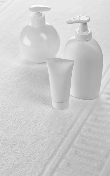 Flessen en buis op witte handdoek — Stockfoto