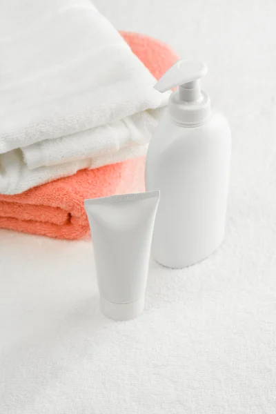 Tubo e frasco de spray com toalhas — Fotografia de Stock