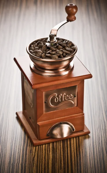 Koffiemolen op houten achtergrond — Stockfoto