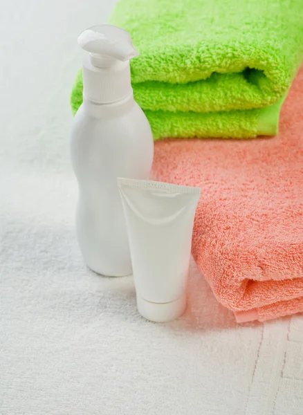 Dva ručníky trubice a láhev — Stock fotografie