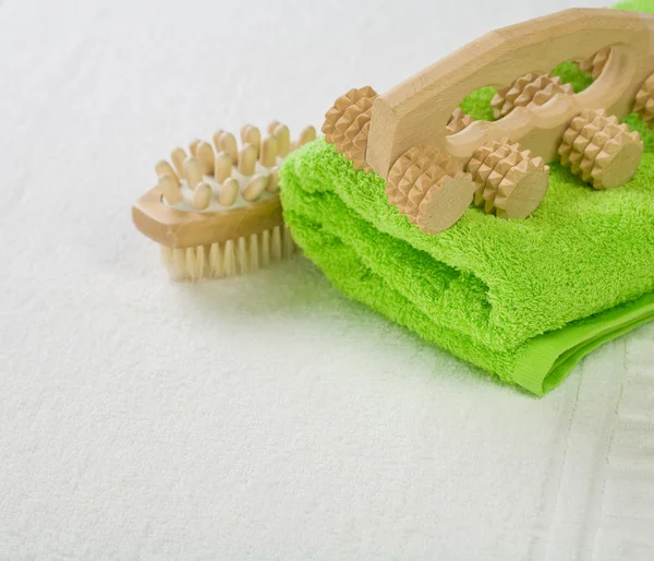 Bürste und Massagegerät mit grünem Handtuch — Stockfoto