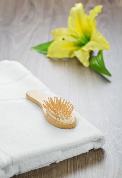Hairbrush and towel with flower — Stock Photo, Image