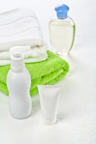 Bottle tube and cotton towels on white background — Stock Photo, Image