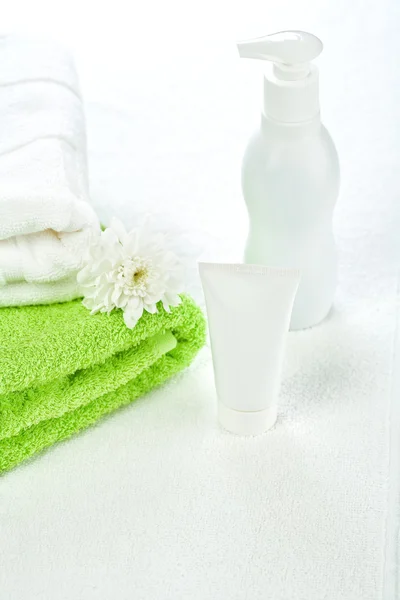 Tubo bottiglia e asciugamani in cotone con fiore — Foto Stock