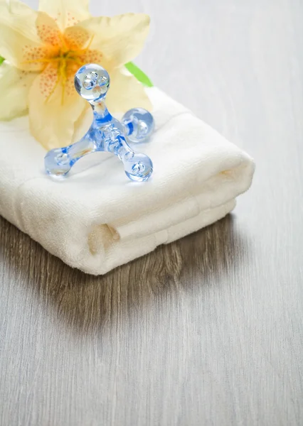 Çiçek ve beyaz havlu üzerinde masaj aleti — Stok fotoğraf