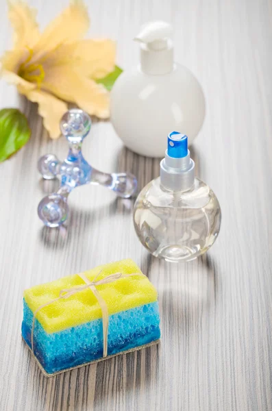 Masseur éponge savon fleur et bouteilles — Photo