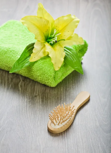 Fiore giallo su asciugamano con spazzola per capelli — Foto Stock