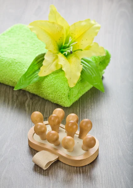 Yellow flower on towel with massager — Stock Photo, Image