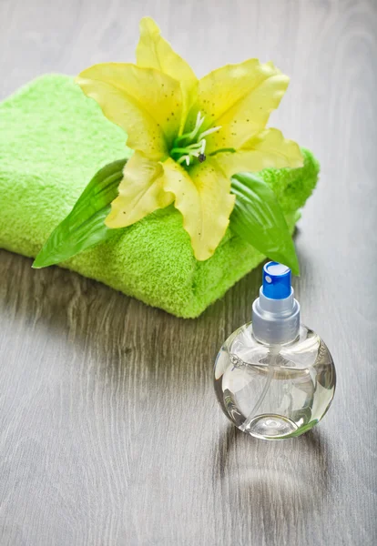 Yellow flower on towel and transparent bottle — Stok fotoğraf