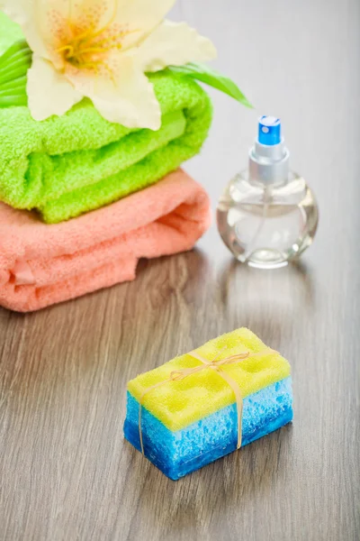 Bath sponge soap flower bottle and towels — Stock Photo, Image