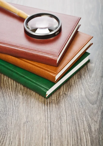 Três cadernos e lupa — Fotografia de Stock