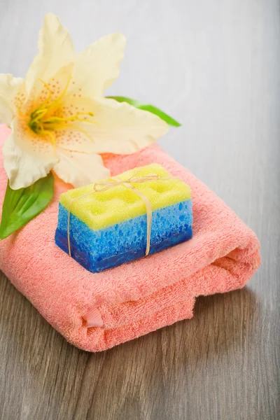 Bad svamp tvål och blomma på handduk — Stockfoto