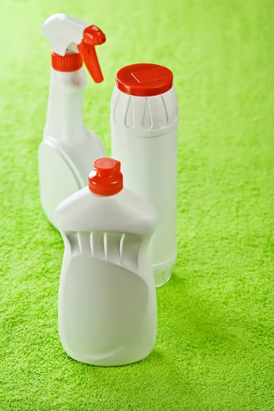 Tres botellas de plástico sobre fondo verde —  Fotos de Stock