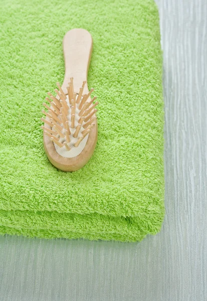 Yeşil havlu üzerinde ahşap saç fırçası — Stok fotoğraf