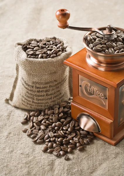 Кофейные зерна в сумке и кофе мельница — стоковое фото