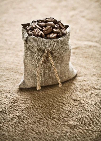 Coffee grains in bag on sacking — Stock Photo, Image