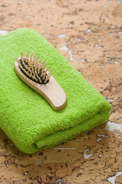 Hairbrush on green towel — Stock Photo, Image