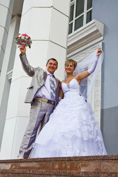 Невеста и жених на заднем плане здания — стоковое фото