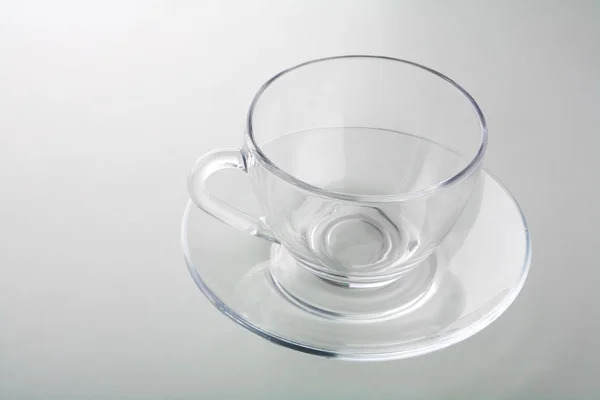 Чашка на тарілці ізольована на сірому — стокове фото