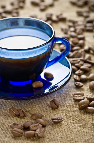 Grãos de café com xícara no pires — Fotografia de Stock