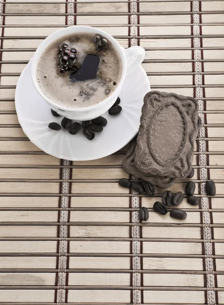 Zusammensetzung der Kaffeetasse mit Bohnen und Keksen — Stockfoto