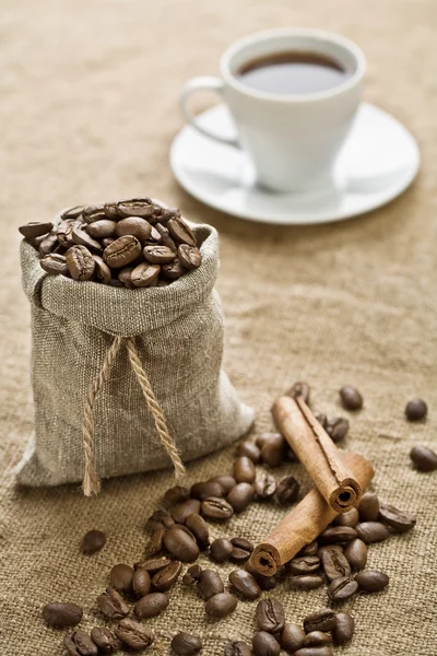 Cinnamon and cup of coffee on sacking — Stock Photo, Image