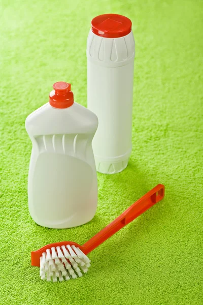 Szczotki i białe butelki na zielonym tle — Zdjęcie stockowe