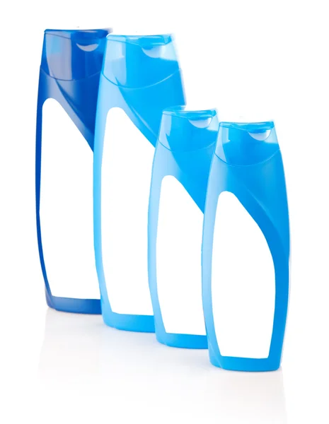 Чотири сині пляшки шампуню — стокове фото