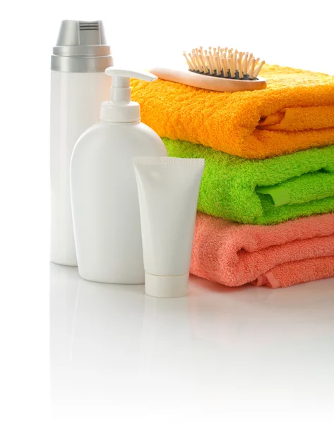 Cepillo para el cabello y botellas con toalla —  Fotos de Stock