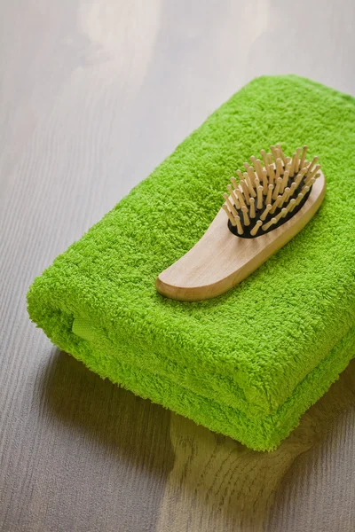Hårborsten på grön handduk — Stockfoto