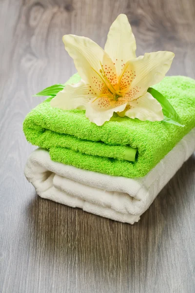 Flower on towels on wooden background — Stock Photo, Image