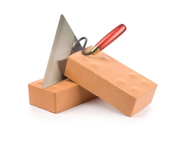 Оранжевый кирпич с лопатой — стоковое фото