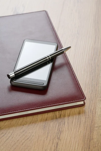 Блокнот з ручкою і мобільним телефоном — стокове фото