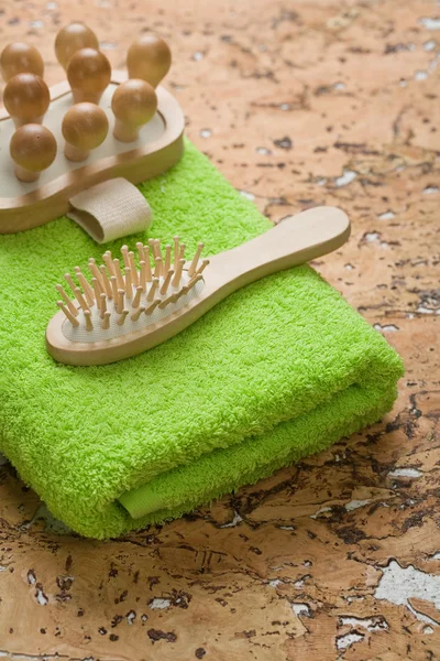 Masajeador y cepillo de pelo en toalla verde —  Fotos de Stock