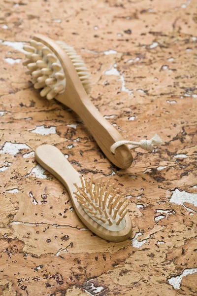Massagegerät und Haarbürste auf Korkholz — Stockfoto