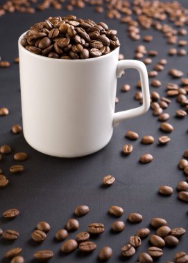 White coffee mug with coffee grains on a black background with c clipart