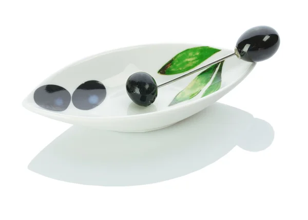 Оливка на тарелке с шампуром — стоковое фото
