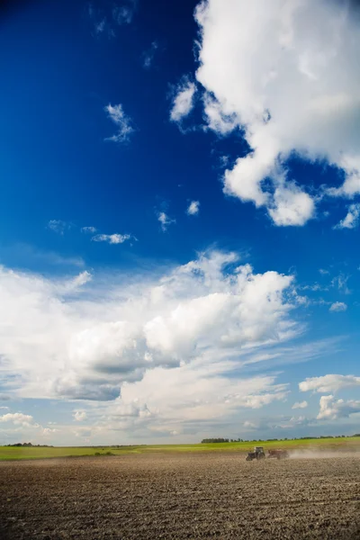 Cielo e campo con trattore — Foto Stock